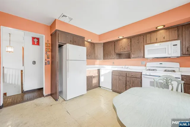 a kitchen with a refrigerator sink and cabinets