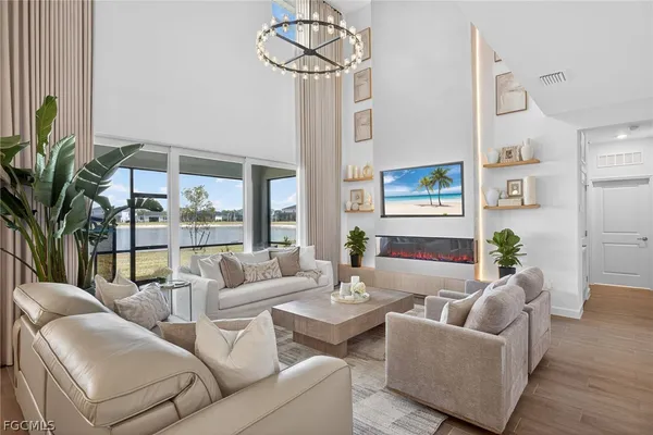a living room with furniture a chandelier and a large window
