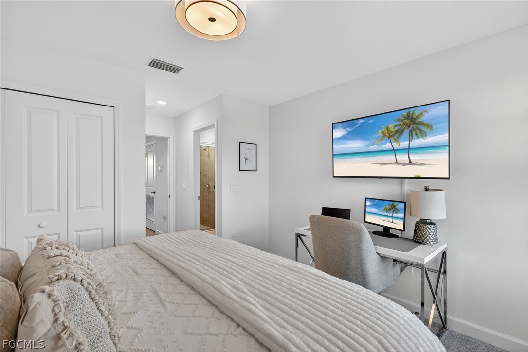 14598 Lagoon Drive Punta Gorda, FL 33982 - Photo 30 of 46 a bedroom with a bed and a chandelier