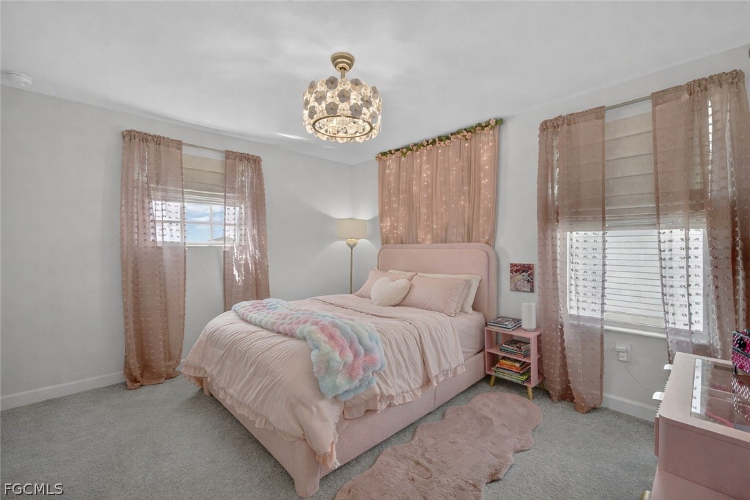 14598 Lagoon Drive Punta Gorda, FL 33982 - Photo 35 of 46 a bedroom with a bed and a chandelier