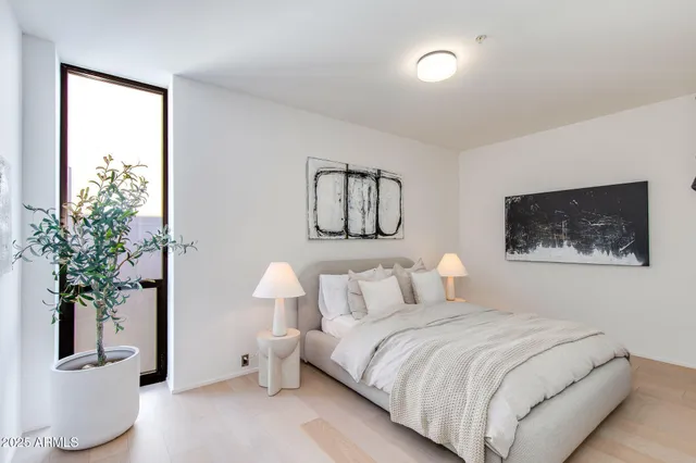 a bedroom with a bed and a potted plant