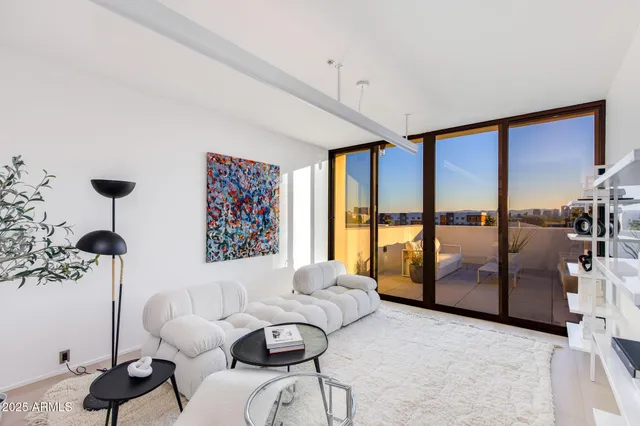 a living room with furniture and a floor to ceiling window