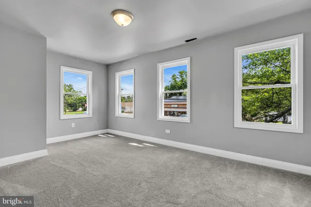 an empty room with windows and closet