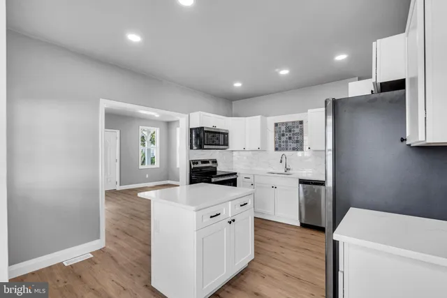 a kitchen with white cabinets and white appliances