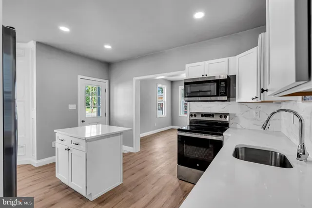 a kitchen with sink a microwave and cabinets