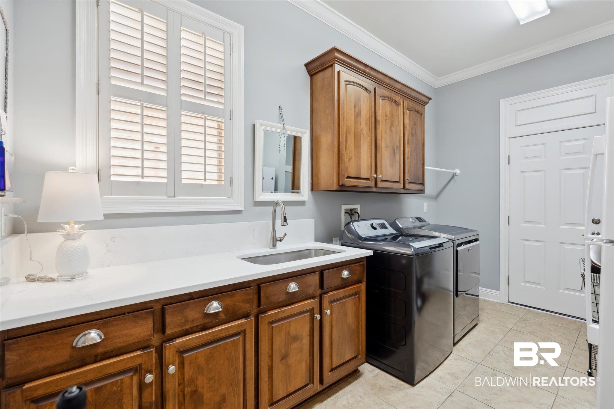 804 Country Club Road Mobile, AL 36609 - Photo 32 of 63 Laundry area featuring light tile patterned flooring, ornamental molding, sink, separate washer and dryer, and cabinets