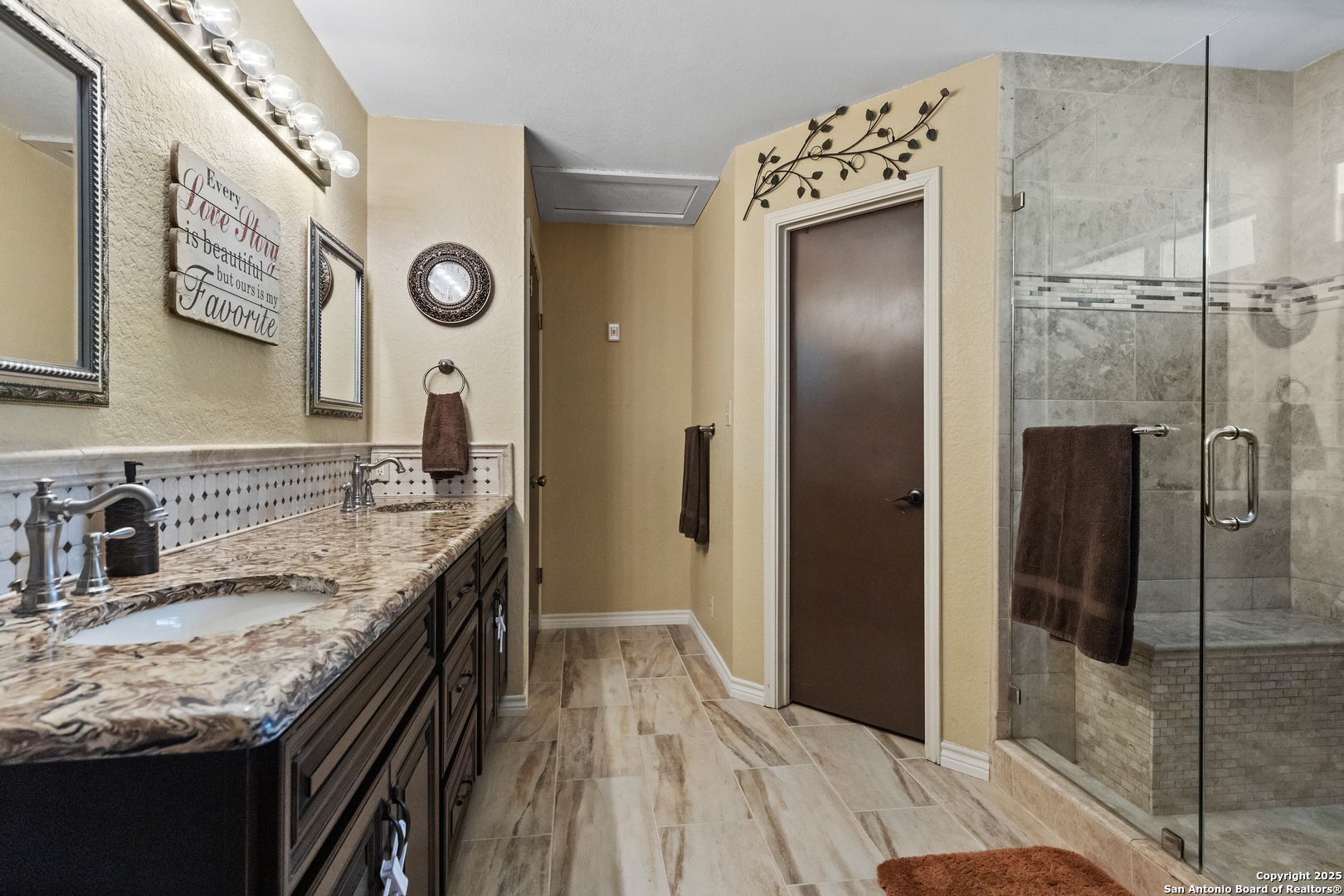 606 Ingram Road Devine, TX 78016 - Photo 22 of 36 a bathroom with a granite countertop sink a mirror and shower