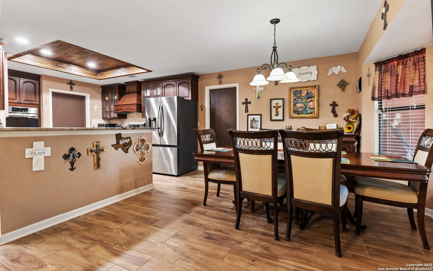 606 Ingram Road Devine, TX 78016 - Photo 10 of 36 a kitchen with stainless steel appliances granite countertop a refrigerator a stove and a dining table with wooden floor
