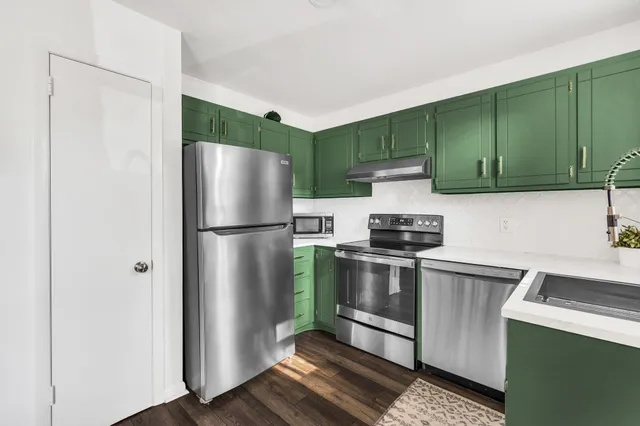 a spacious bedroom with a bed a chair and a large window