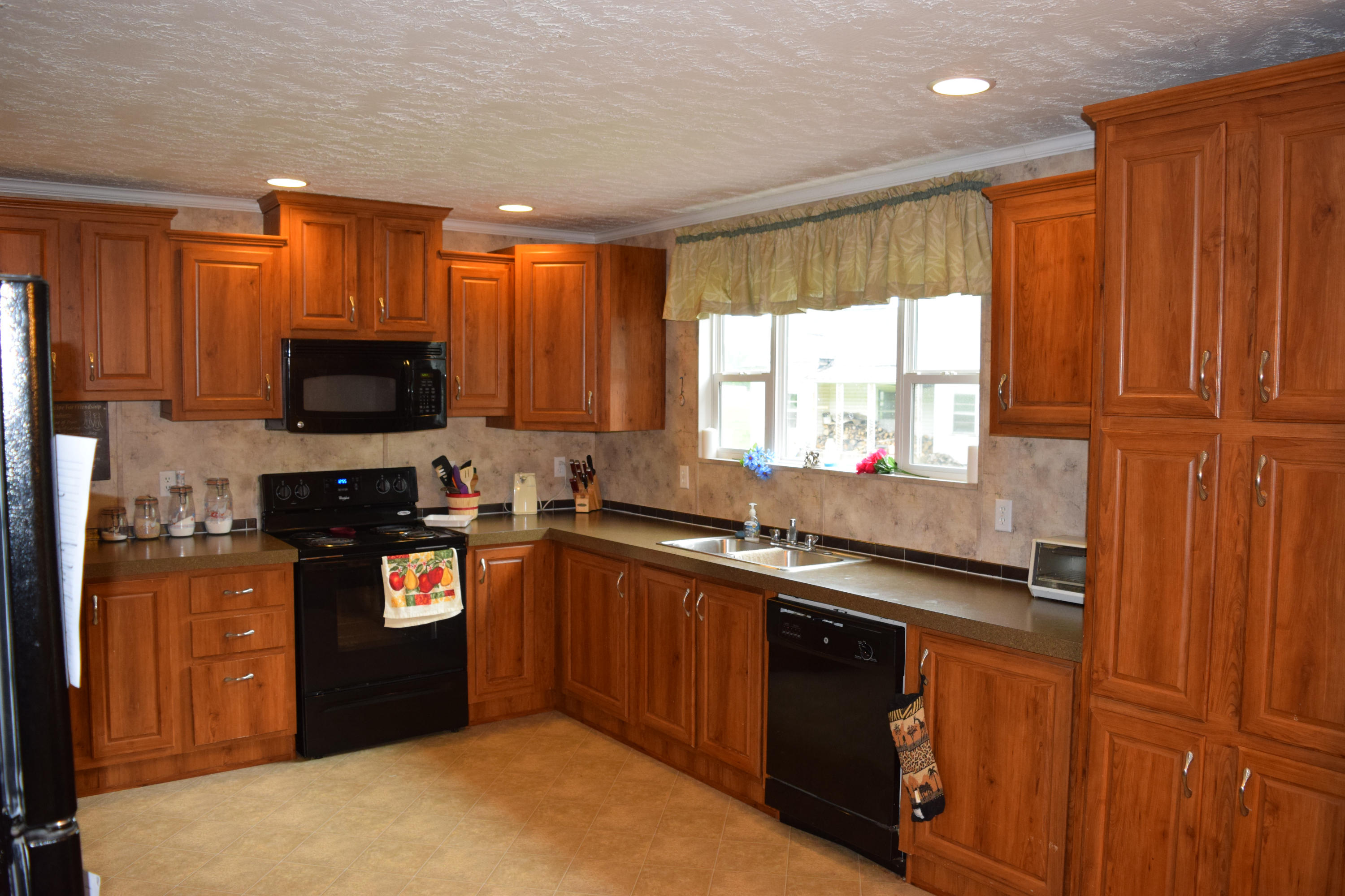 4752 Waidsboro Road Ferrum, VA 24088 - Photo 17 of 38 a kitchen with granite countertop a stove a sink dishwasher and a microwave oven with cabinets