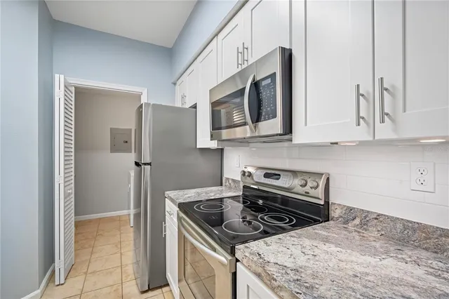 a kitchen with stainless steel appliances granite countertop a stove microwave and refrigerator