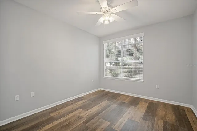 an empty room with a window and a fan