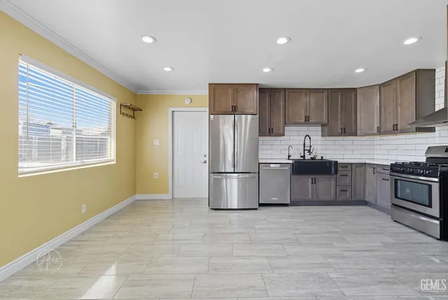 a kitchen with stainless steel appliances a refrigerator and a stove top oven