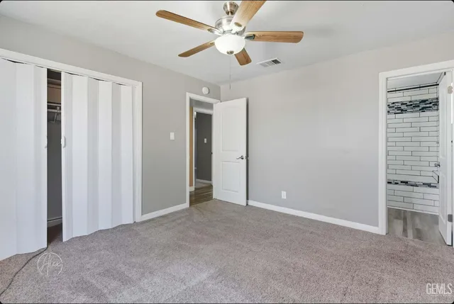 a view of an empty room with a ceiling fan