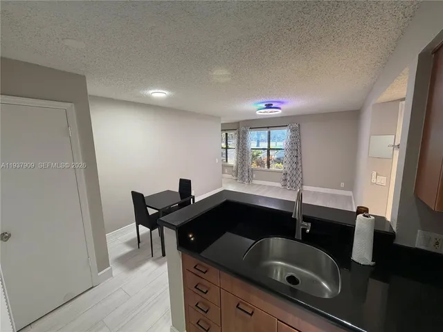 a bath room with a sink a mirror and a window