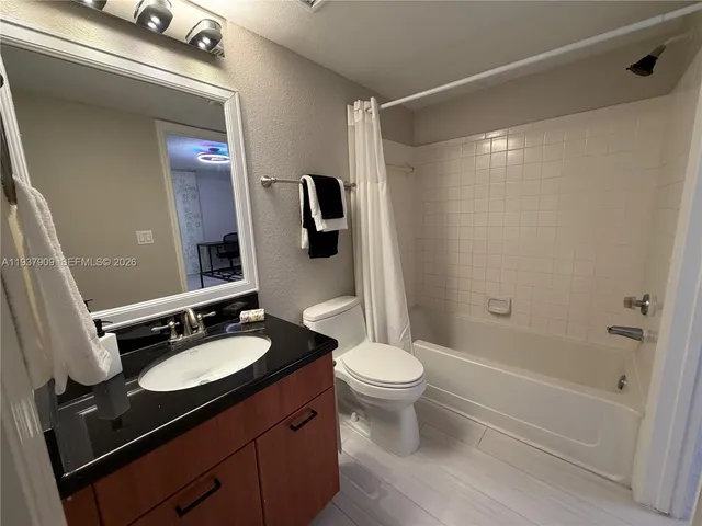 a bathroom with a sink a toilet a mirror and shower