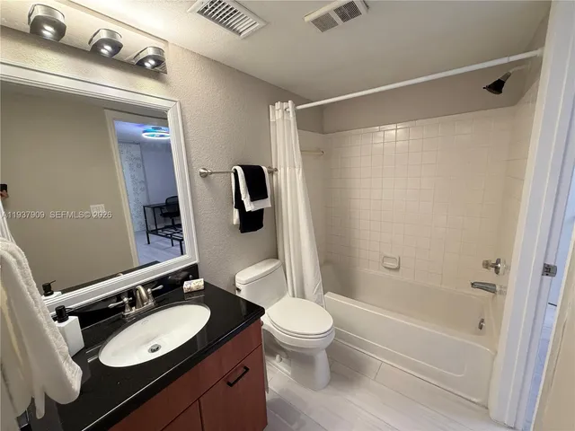a bathroom with a sink a toilet a mirror and shower