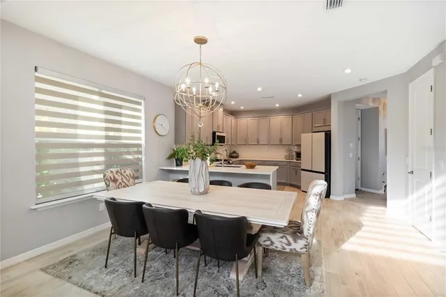 a kitchen with stainless steel appliances granite countertop a refrigerator sink and white cabinets