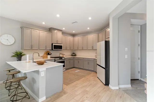 a kitchen with a sink stainless steel appliances and white cabinets