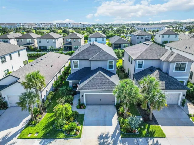 an aerial view of residential houses with outdoor space and trees