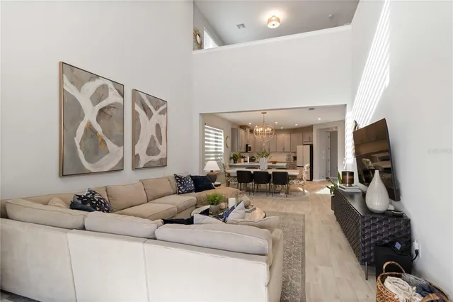 a kitchen with stainless steel appliances granite countertop a dining table chairs and white cabinets