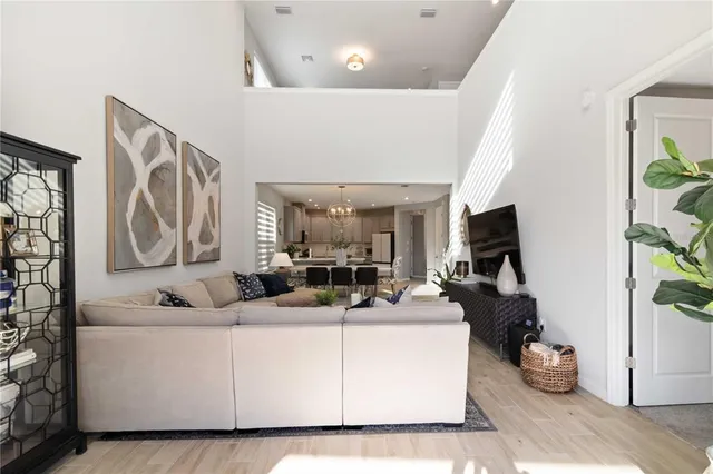 a living room with furniture a chandelier and a flat screen tv