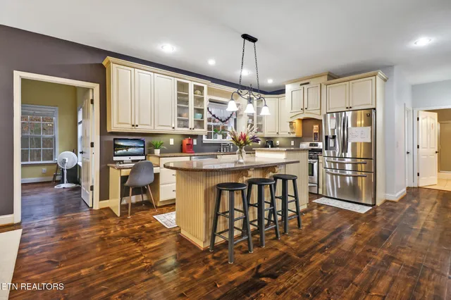 a kitchen with stainless steel appliances granite countertop a stove a sink and a granite counter tops with white cabinets