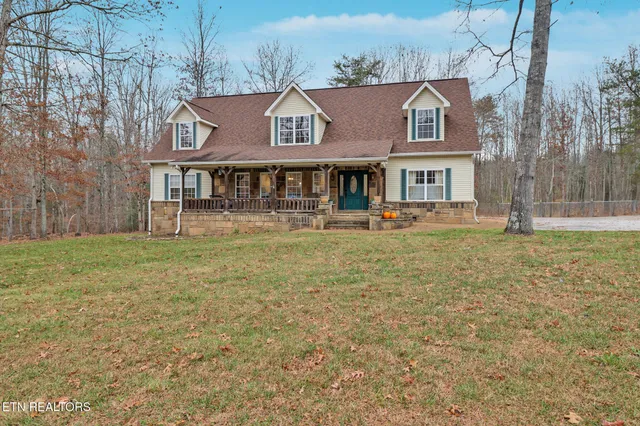 a front view of house with yard and trees in the background