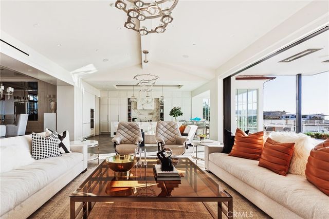 a living room with furniture chandelier and a large window