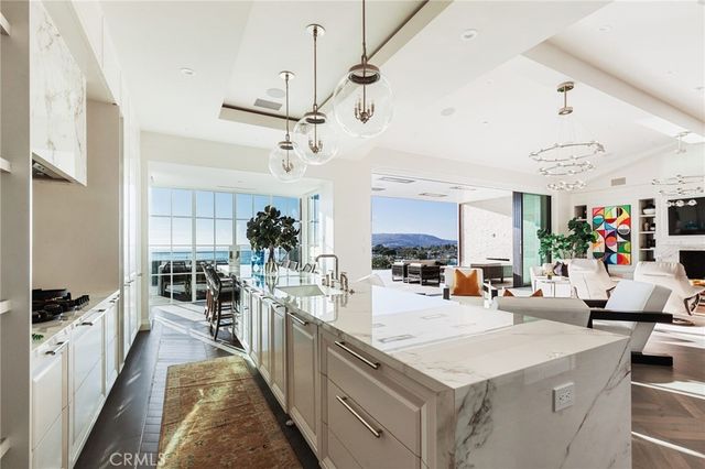a large white kitchen with lots of counter space and view living room