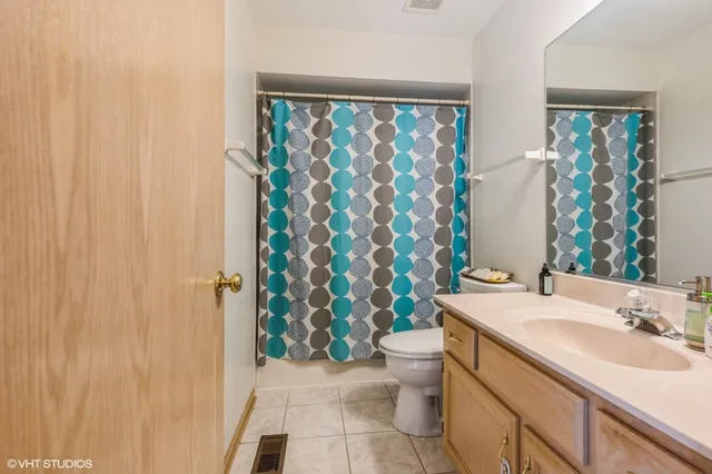 a bathroom with a sink a toilet and shower curtain