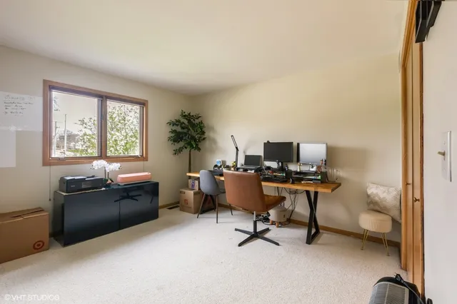 a view of a workspace with furniture and a window