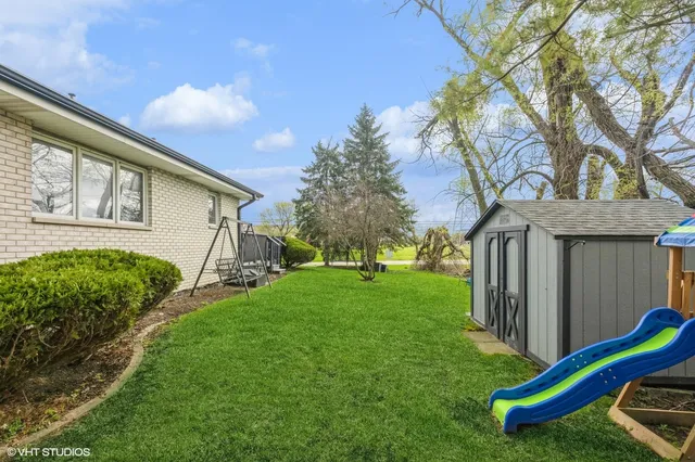 a backyard of a house with plants and wooden fence