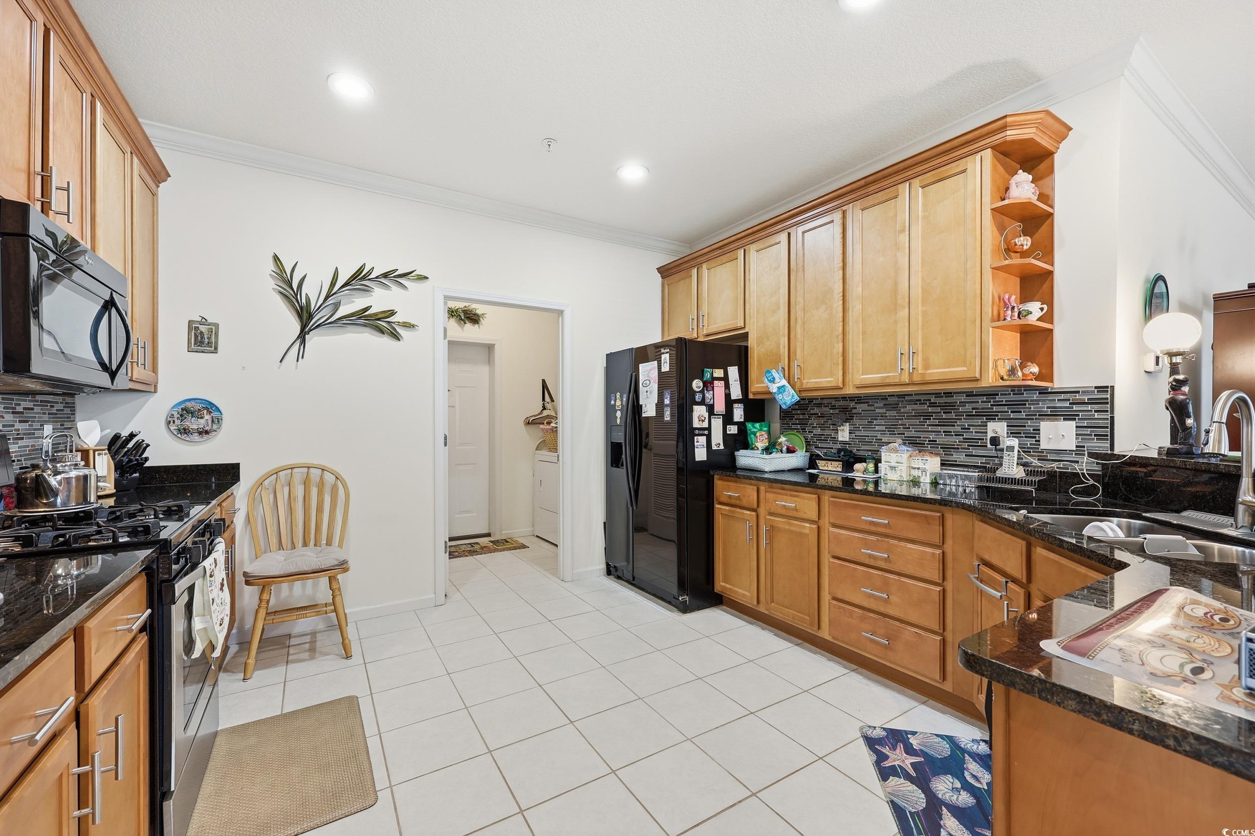822 Sail Lane, Unit 103 Murrells Inlet, SC 29576 - Photo 14 of 37 Kitchen with decorative backsplash, black appliances, dark stone countertops, open shelves, and ornamental molding