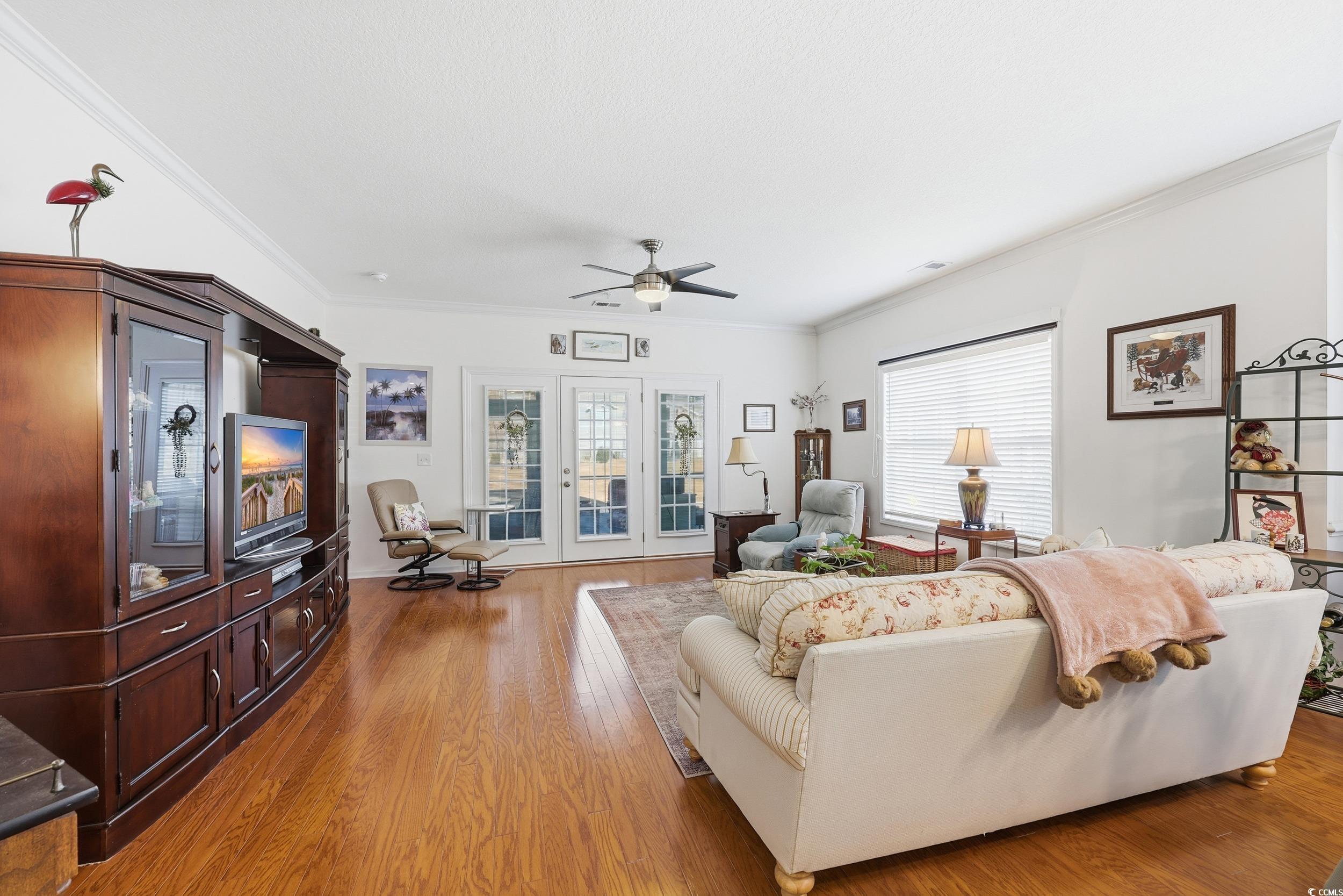 822 Sail Lane, Unit 103 Murrells Inlet, SC 29576 - Photo 17 of 37 Living room featuring plenty of natural light, light wood-style floors, crown molding, and ceiling fan