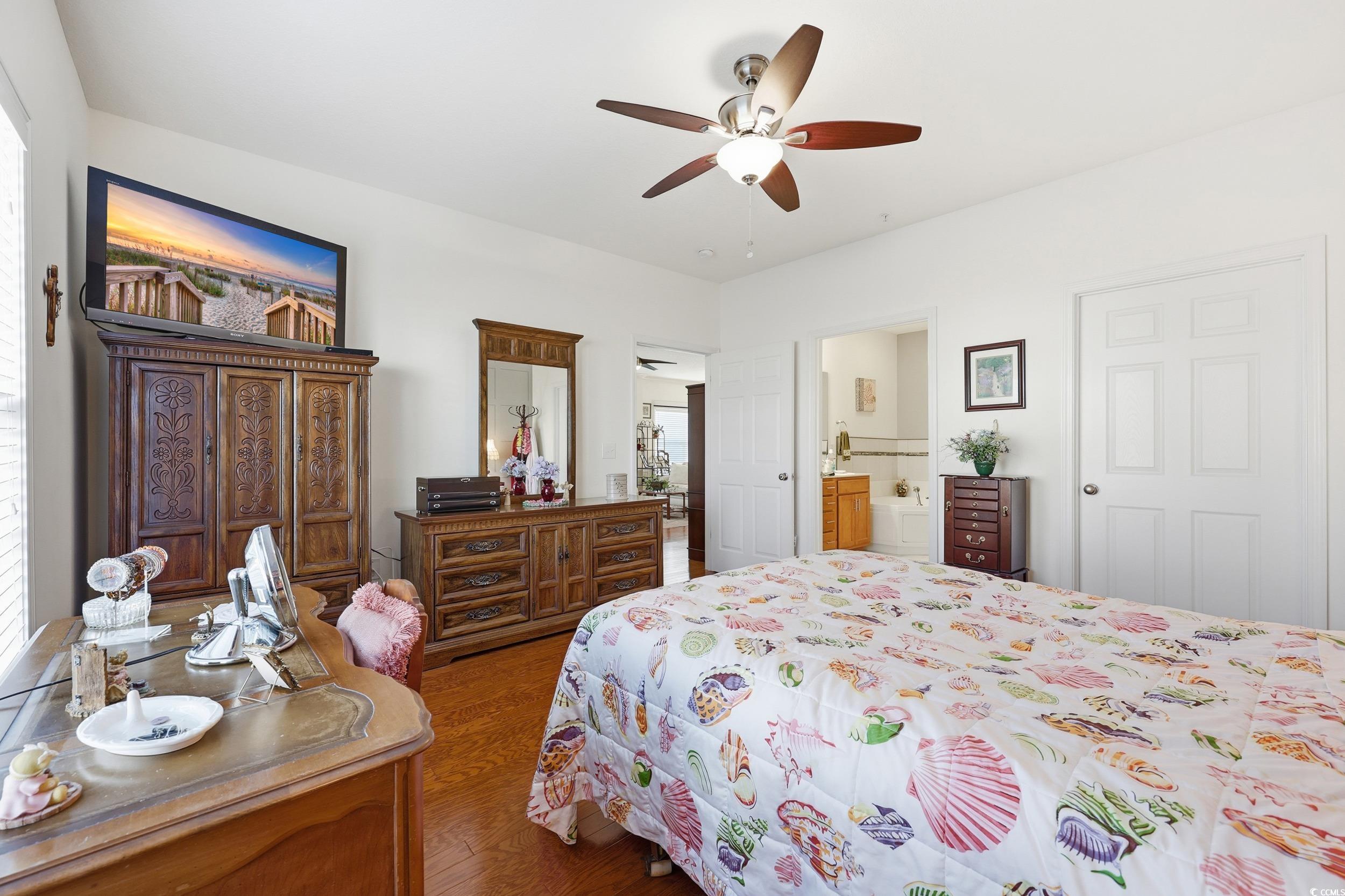 822 Sail Lane, Unit 103 Murrells Inlet, SC 29576 - Photo 19 of 37 Bedroom featuring wood finished floors, a ceiling fan, and ensuite bath