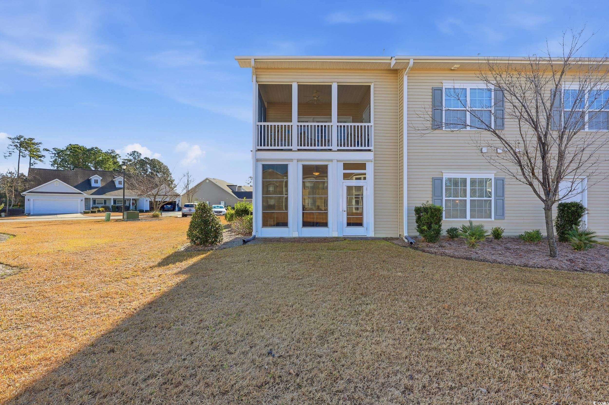 822 Sail Lane, Unit 103 Murrells Inlet, SC 29576 - Photo 30 of 37 Back of property featuring a sunroom, a lawn, and a balcony