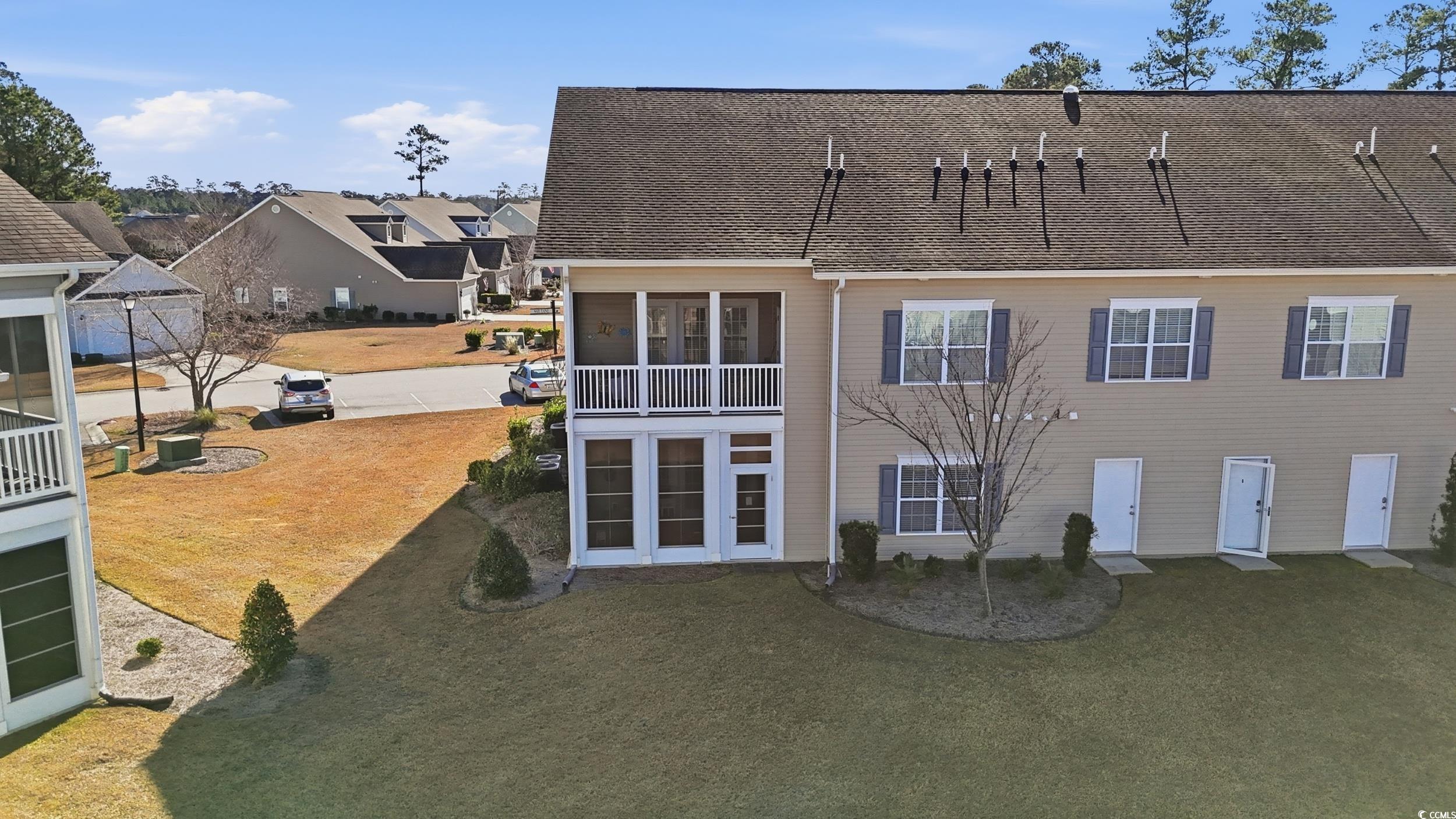 822 Sail Lane, Unit 103 Murrells Inlet, SC 29576 - Photo 31 of 37 Rear view of house featuring a lawn, a sunroom, and a shingled roof