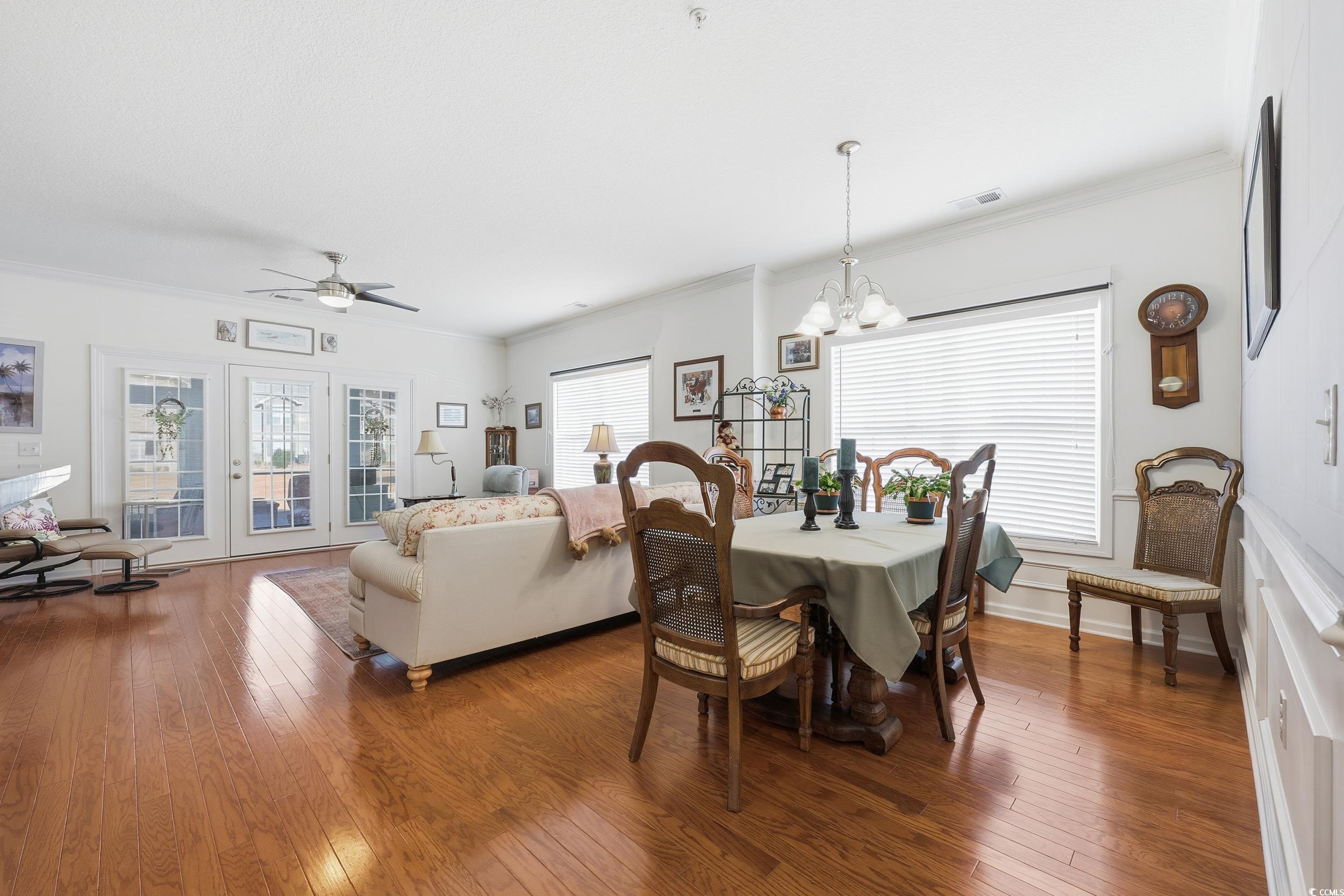 822 Sail Lane, Unit 103 Murrells Inlet, SC 29576 - Photo 10 of 37 Dining space featuring crown molding, hardwood / wood-style floors, a ceiling fan, and a chandelier
