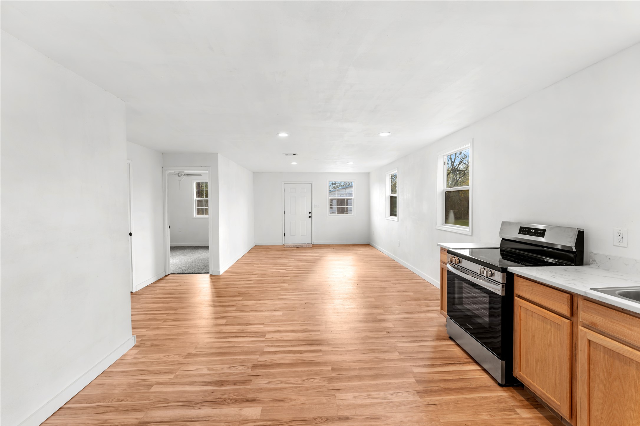a view of a kitchen with wooden floor electronic appliances and furniture