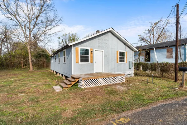 a view of a house with a yard and wooden fence