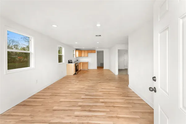 a big room with wooden floor and windows