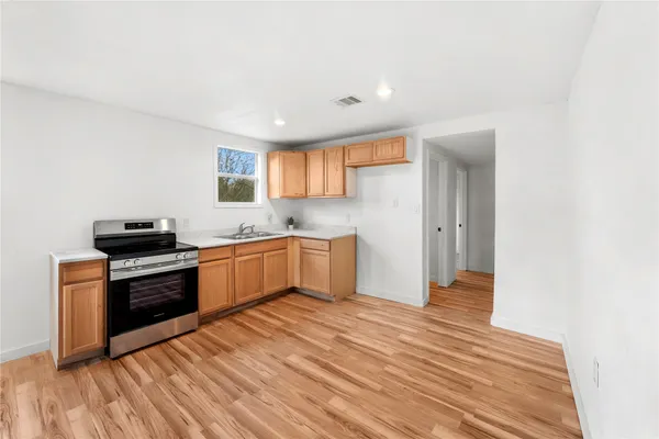 a kitchen with granite countertop a stove and a sink