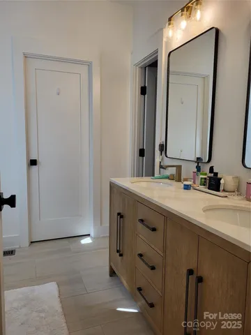a bathroom with a double vanity sink and mirror
