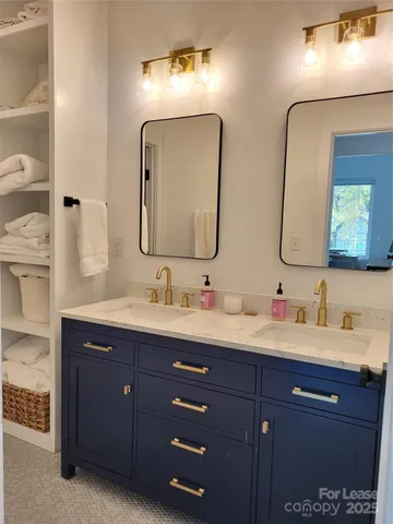 a bathroom with double vanity sinks and a mirror