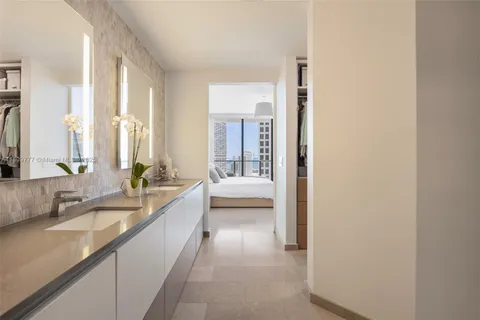 a large en suite bathroom with a double vanity sink and a large mirror
