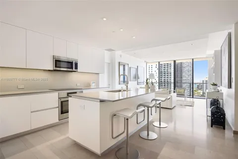 a kitchen with stainless steel appliances granite countertop a stove a sink and a refrigerator with wooden floor