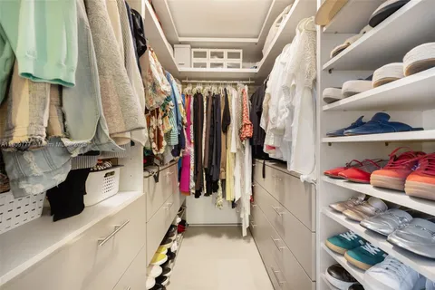 a view of walk in closet with clothes and shoes