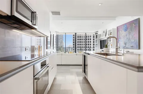 a large white kitchen with stainless steel appliances
