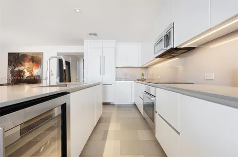 a kitchen with granite countertop white cabinets and white appliances